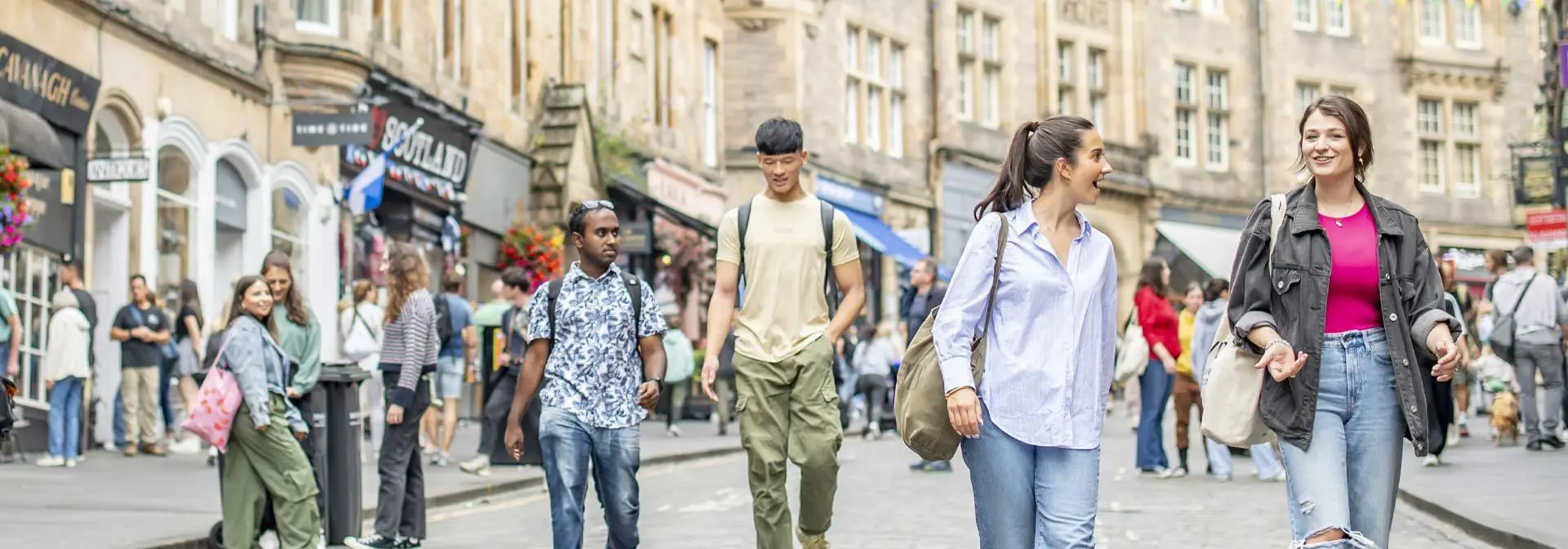 students chat as they walk down Cockburn Street in Edinburgh