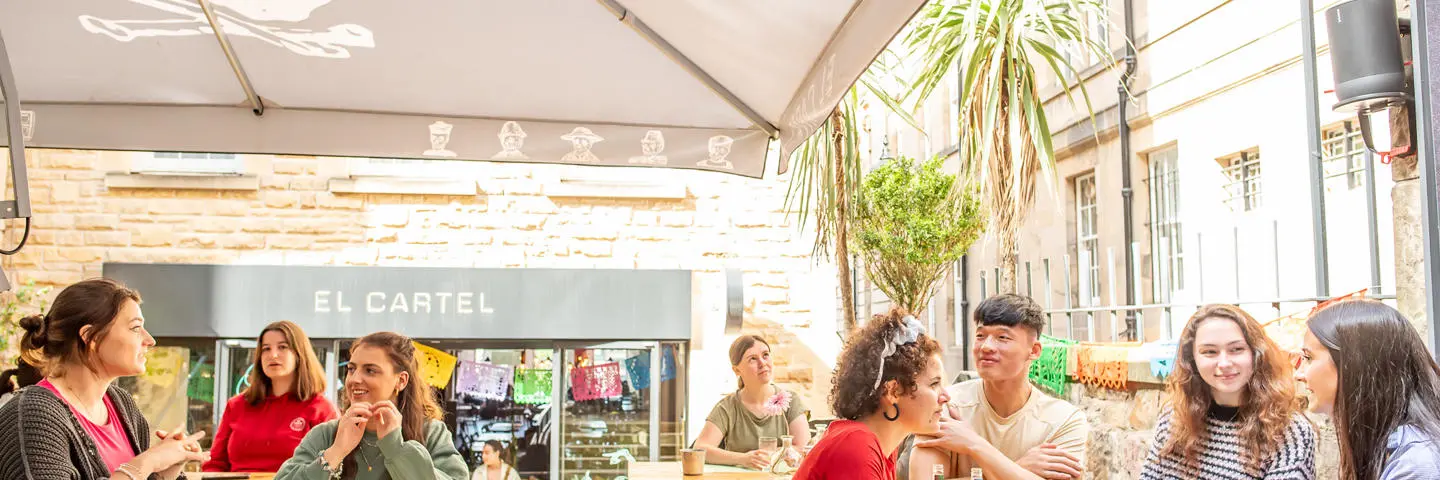 Students sitting in Edinburgh city in a restaurant outside