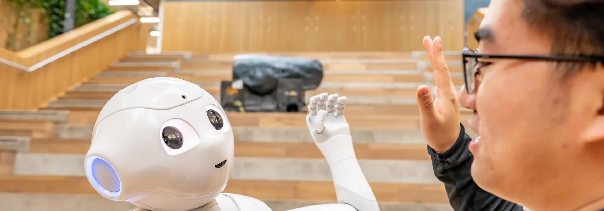 A robot high fives a man in the National Robotarium