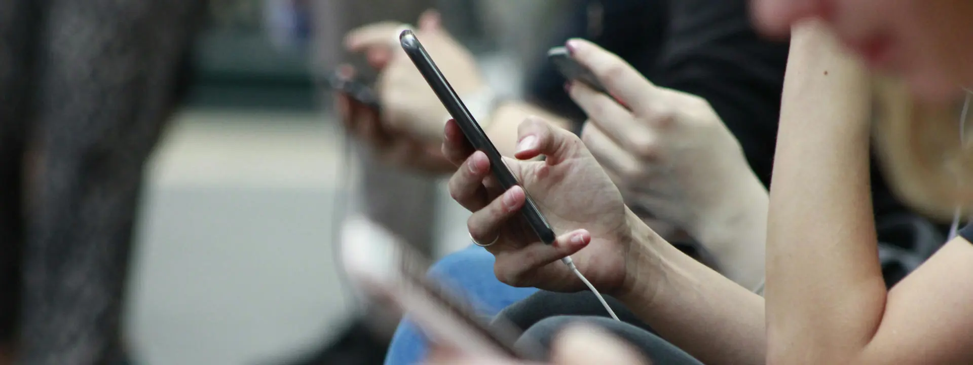 Commuters scrolling through their phones. Photo by Robin Worrall on Unsplash.