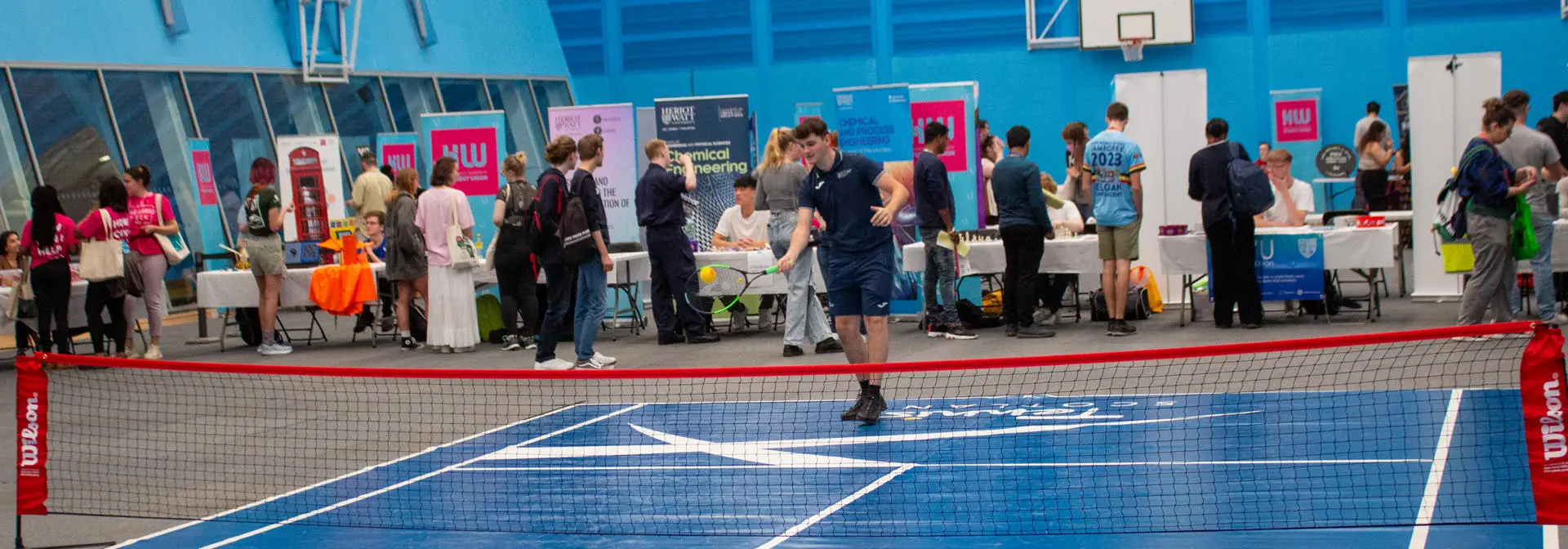 An individual plays tennis indoors