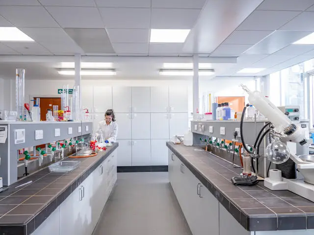 A chemical laboratory with multiple cupboards and equipment on display.